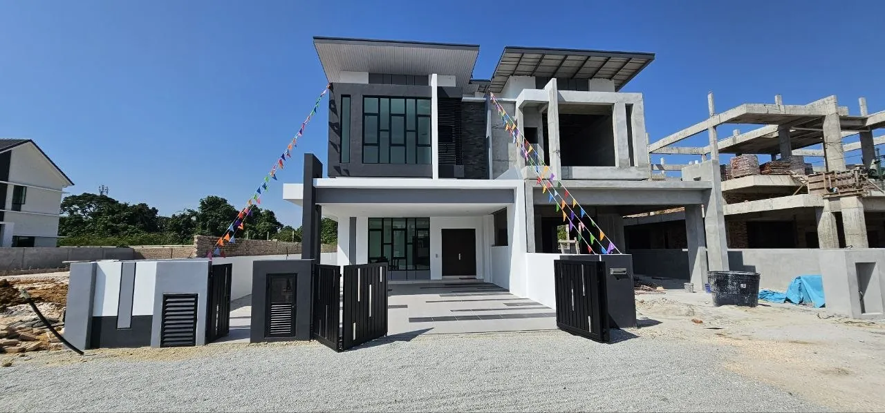 Pinggiran Pengkalan Bayu show house facade with gated porch, next to a unit under construction
